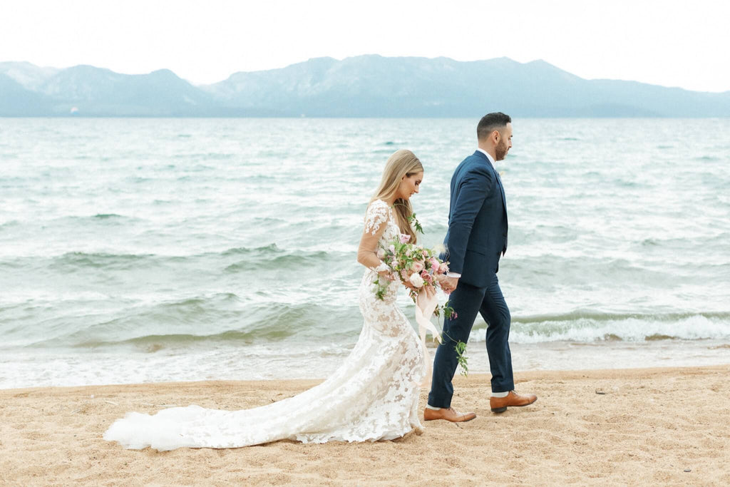 Bride and groom walking on the beach at their Edgewood Tahoe wedding