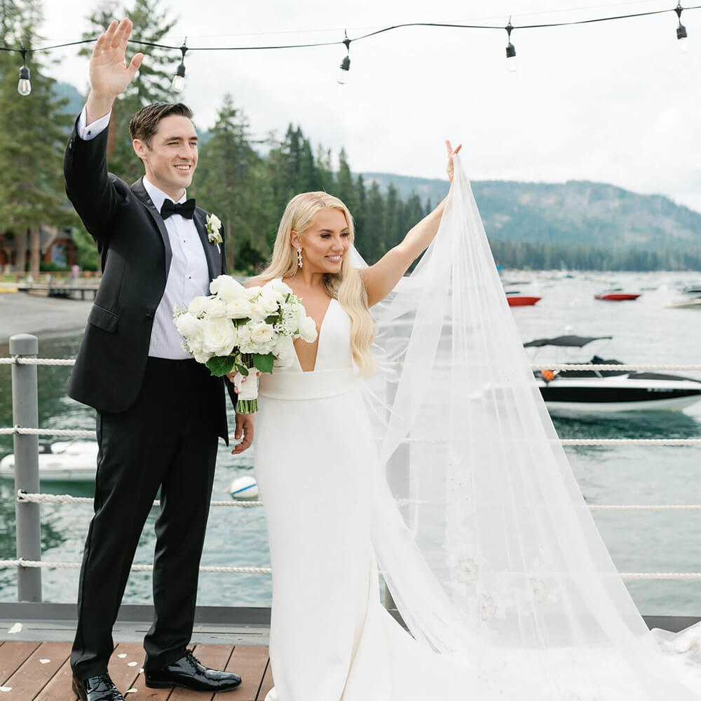Wedding couple waving from a dock in Lake Tahoe